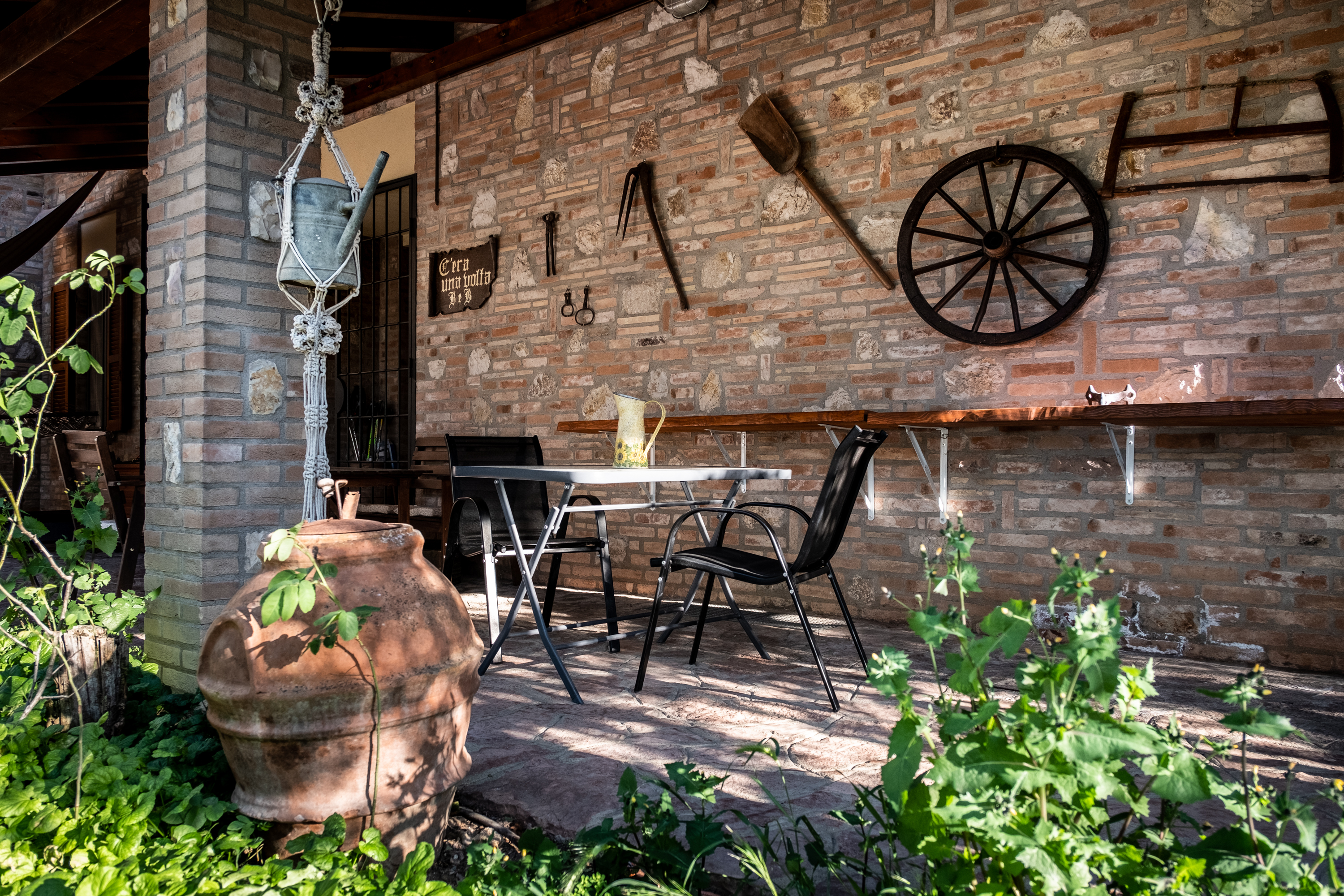 A charming porch and giardino relax area decorated with traditional vintage farming tools.