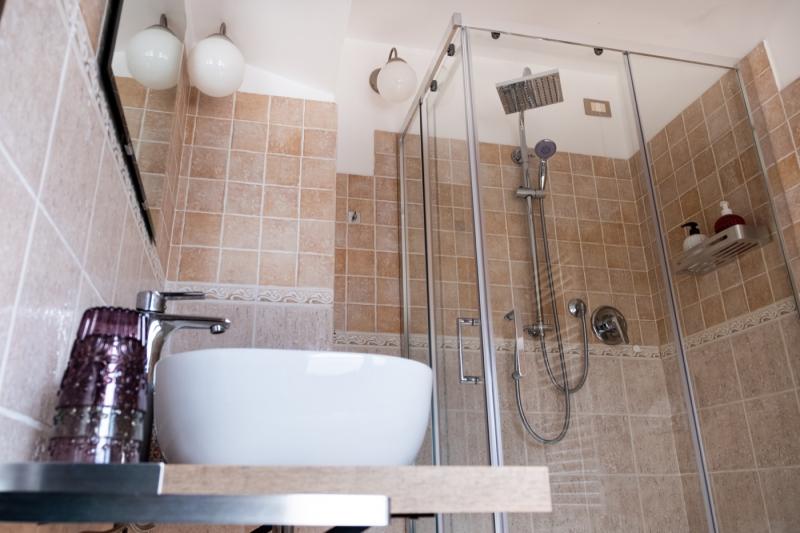 The modern bathroom of the Papavero Room at C'era una Volta B&B, featuring a stylish vessel sink and wooden counter The modern bathroom of the Papavero Room at C'era una Volta B&B, featuring a stylish vessel sink and wooden counter