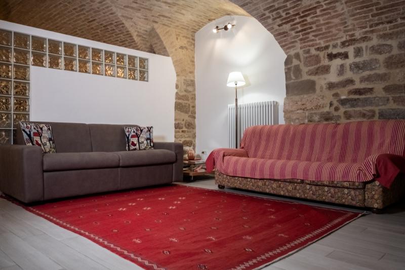 A charming living area with historic stone walls and vaulted ceilings at Domus Romana.