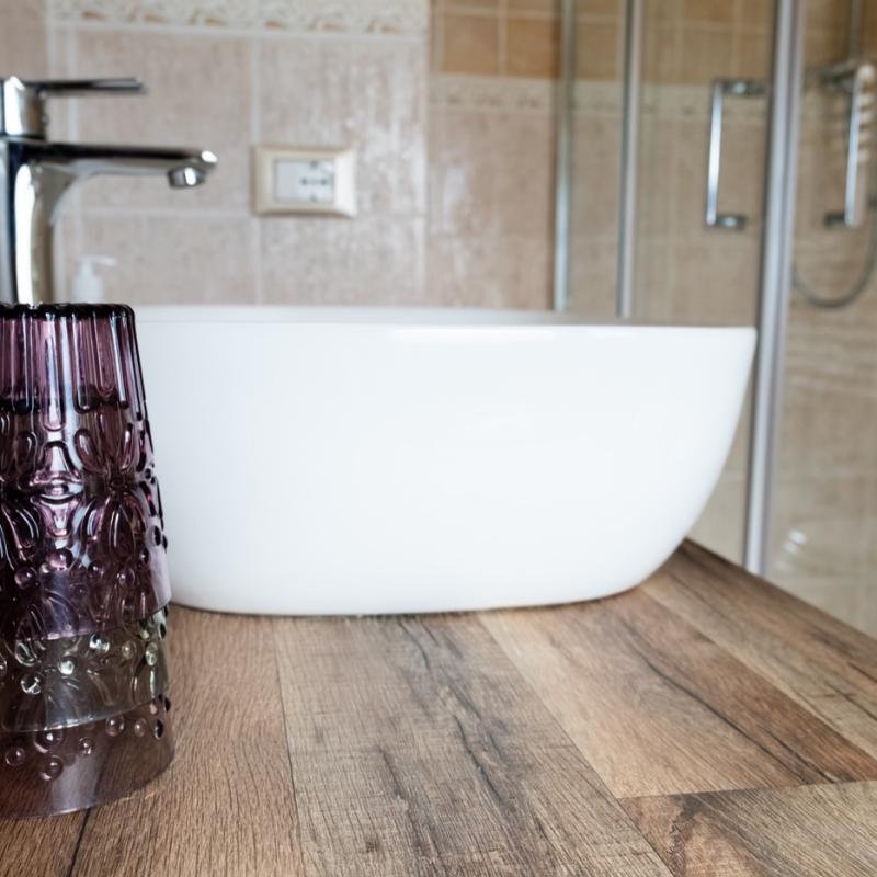 The modern bathroom of the Papavero Room at C'era una Volta B&B, featuring a stylish vessel sink and wooden counter