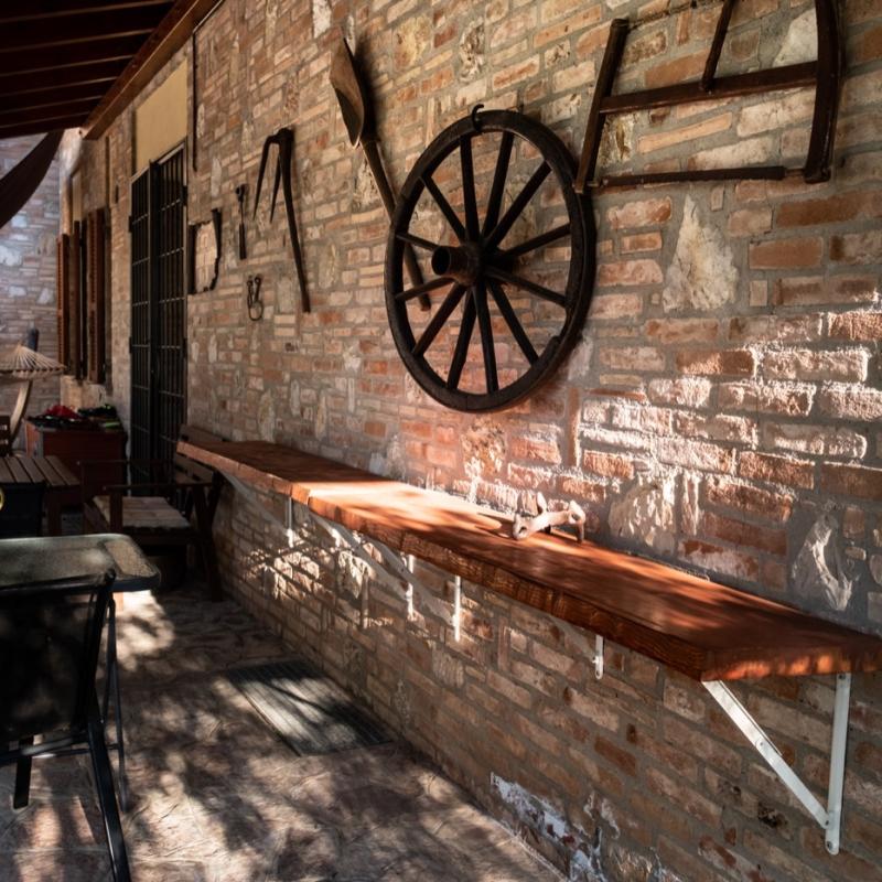 A charming porch and giardino relax area decorated with traditional vintage farming tools.